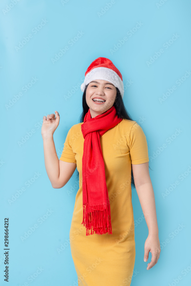 Asian woman in yellow dress wearing red scarf and Santa hat, holidays concept. Asian woman in yellow dress wearing red scarf and Santa hat, holidays concept.