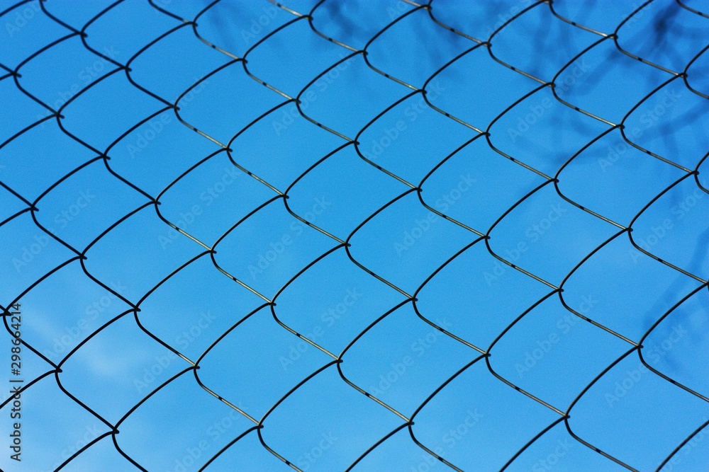 Black metal mesh on the background and blue sky Black metal mesh on the background and blue sky