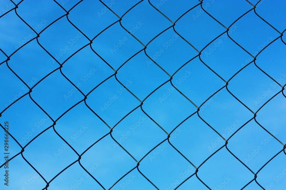 Black metal mesh on the background and blue sky Black metal mesh on the background and blue sky