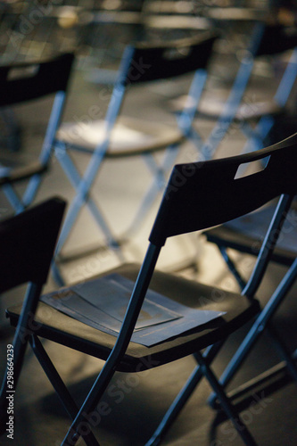 Rows of plastic folding chairs in empty auditorium for guests and participants of the event.