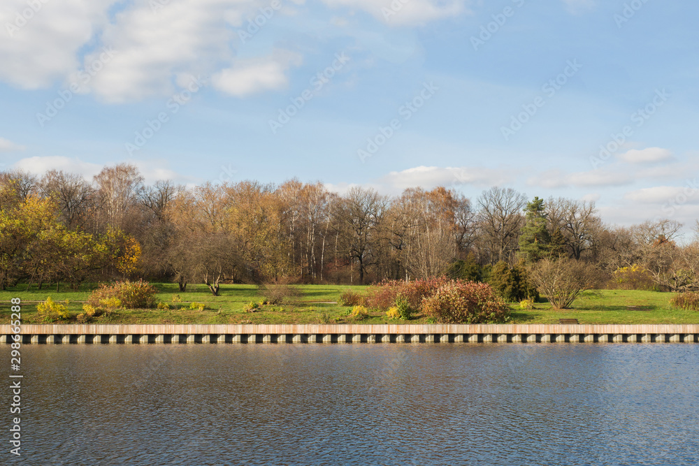 Beautiful autumn trees in yellow colors are reflected in the water of the pond in the Park. Beautiful autumn trees in yellow colors are reflected in the water of the pond in the Park.