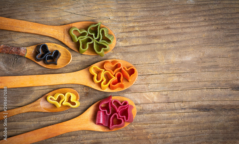 Heart shape macaroni pasta on wooden spoons Heart shape macaroni pasta on wooden spoons
