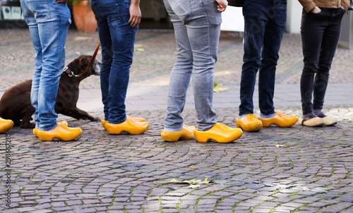 Photography Close up of blue jeans legs of group of people wearing traditional wooden clogs