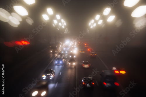 Busy traffic in city fog blur lights of cars on road