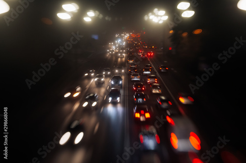 Busy traffic in city fog blur lights of cars on road