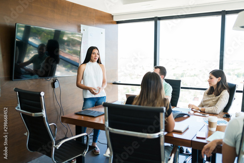 Businesswoman Giving Presentation In Meeting At Office