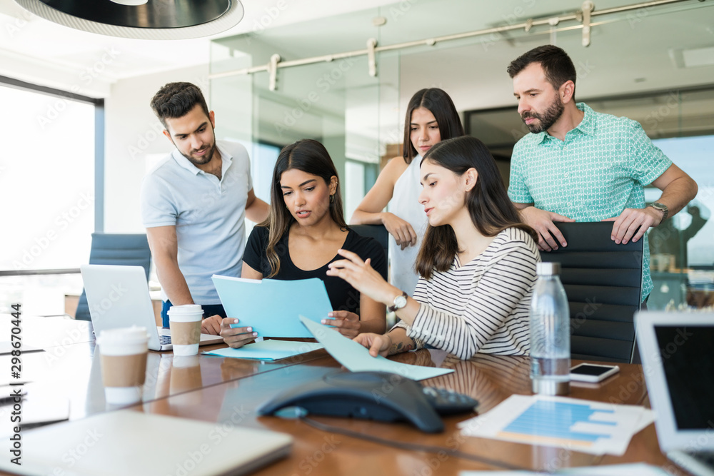 Hispanic Colleagues Coworking In Meeting Room