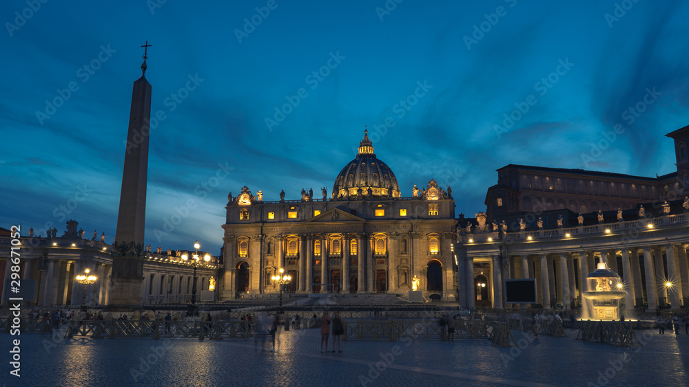 A night picture of The Papal Basilica of St. Peter in the Vatican. St Peter's, Bernini's colonnade and Maderno's fountain at night during blure hour.