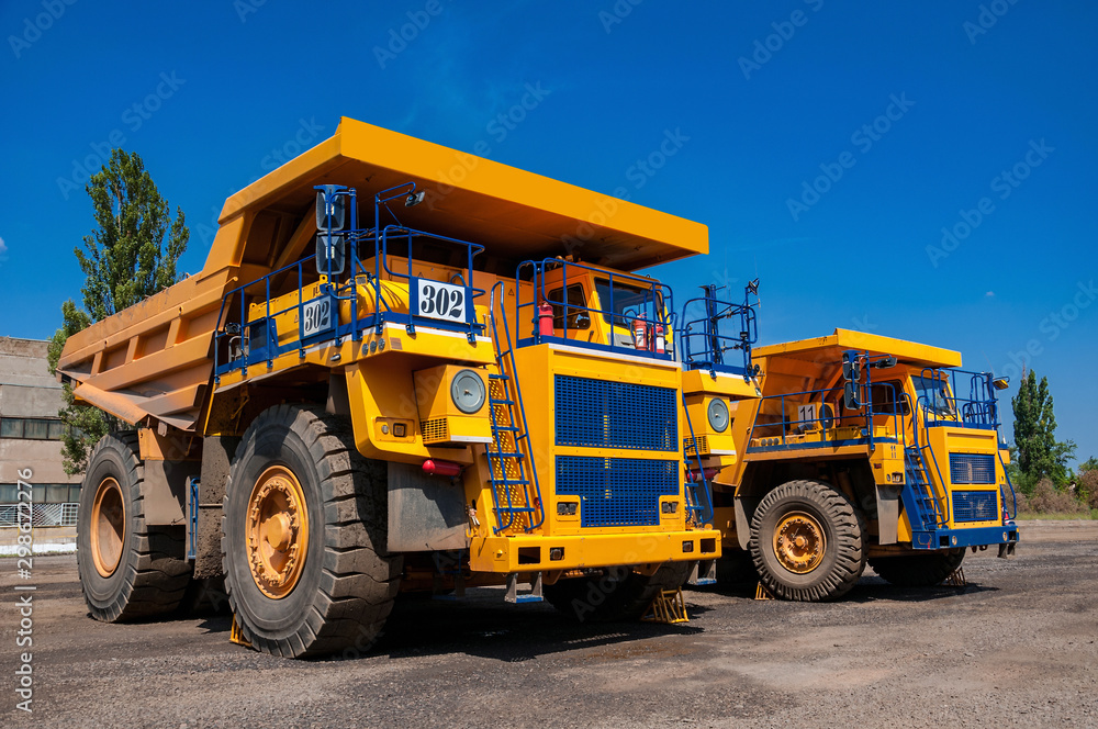 heavy yellow quarry dump truck at repair station at sunny cloudless day heavy yellow quarry dump truck at repair station at sunny cloudless day
