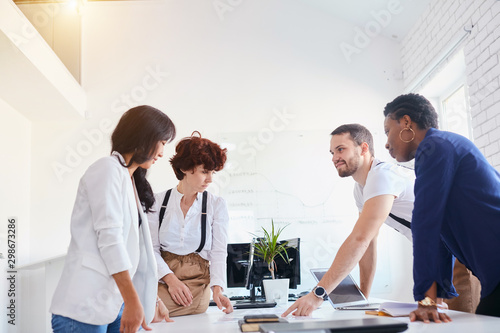 diverse company staff workers group chatting, discussing in white office