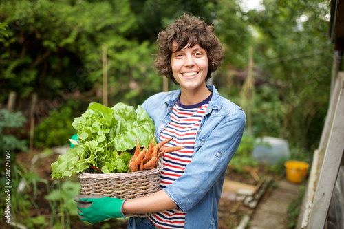 Obraz na plátně smiling farmer with bunch of vegetables in basket