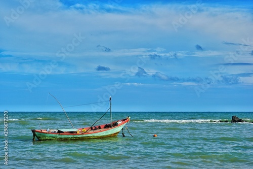 Fishing boat floating in the sea with blue sky.