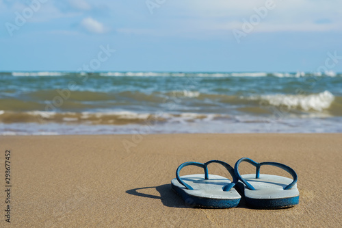 Sandals on the beach, sea and sky as the background.