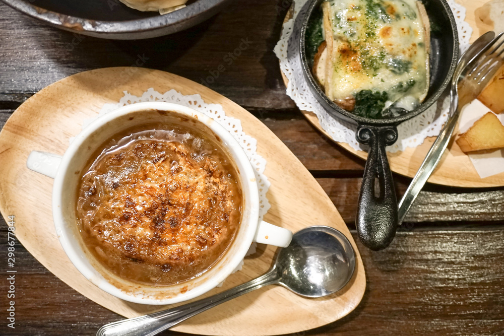 Onion Soup and spinach cheese top view on the wooden table. Rustic. Selective focus on the onion soup. Onion Soup and spinach cheese top view on the wooden table. Rustic. Selective focus on the onion soup.
