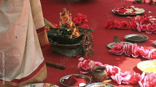Indian wedding ceremony, decorations for traditional ethnic rituals for marriage, fire burning, flowers and statuettes of the deity on red carpet