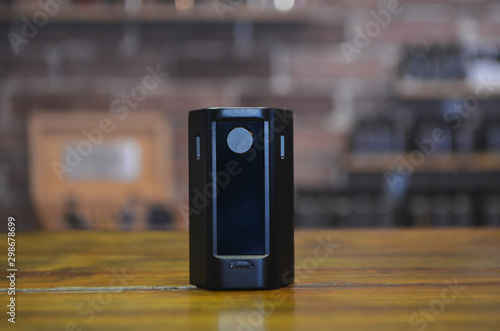 Electronic cigarette on a background of vape shop. E-cigarette for vaping. photo