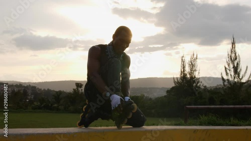 Wallpaper Mural clip of man sitting on the ramp and putting on rollerblades, in a beautiful african sunset Torontodigital.ca