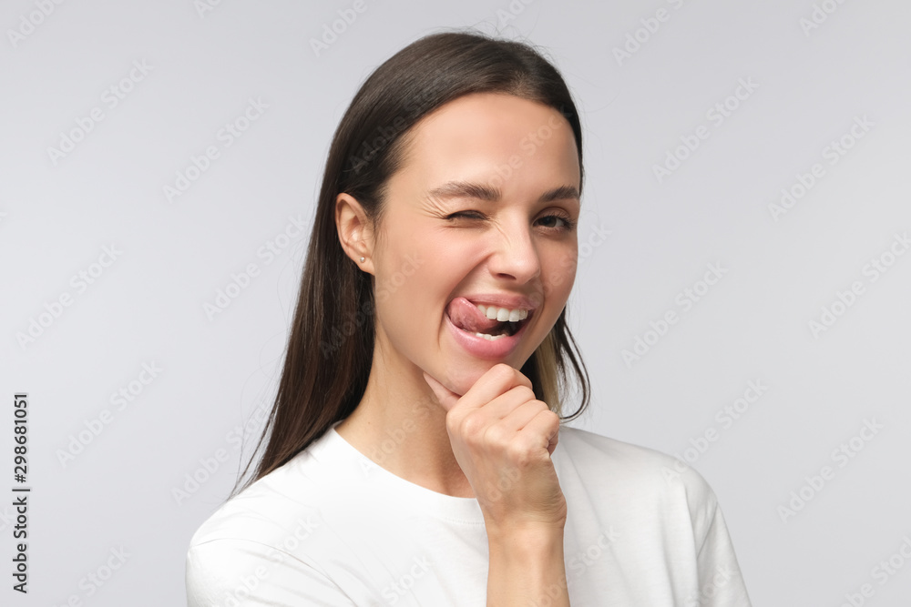 Young beautiful woman smiling and winking, looking at camera Young beautiful woman smiling and winking, looking at camera