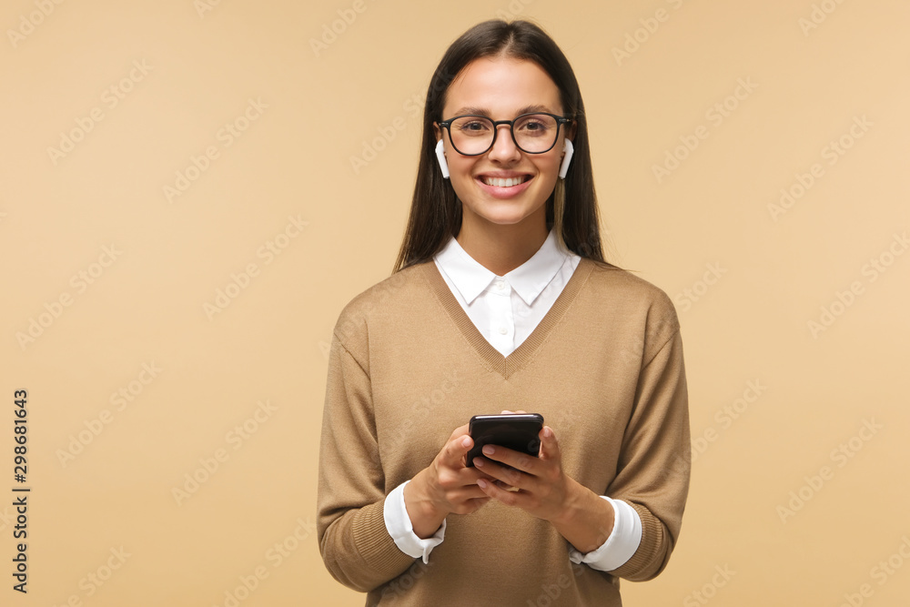 Closeup of brunette female with wireless earphones on, listening to music or voice messages, isolated on background Closeup of brunette female with wireless earphones on, listening to music or voice messages, isolated on background