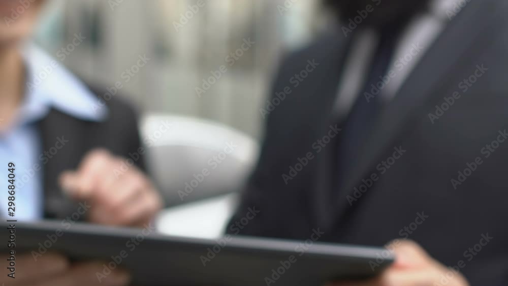 Man signing car purchase contract online on tablet lady giving auto keys to male Man signing car purchase contract online on tablet lady giving auto keys to male