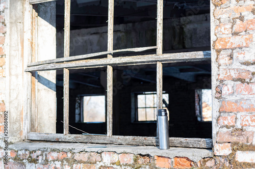 Iron bottle by the window. Thermos by the window on the ledge. photo