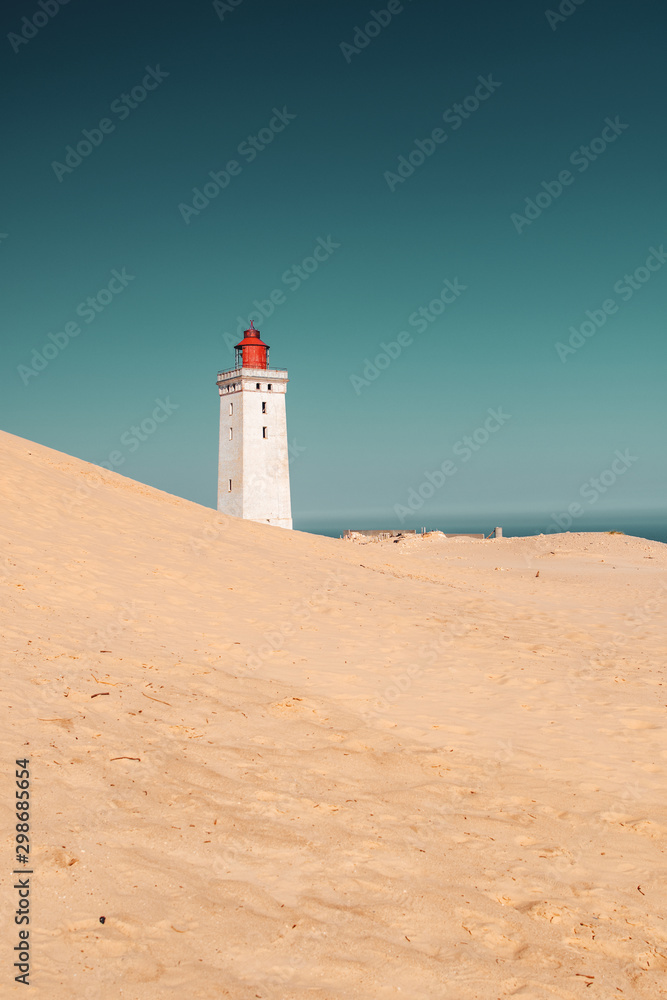 Famous danish lighthouse Rubjerg Knude in endless wide sand dune landscape on a bright summer day. Denmark, Europe 