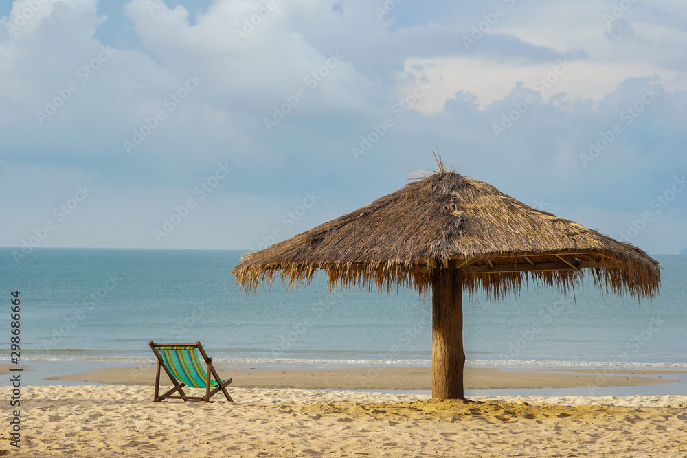 The morning sea has chairs and umbrellas on the beach as the foreground and the sea with the sky as the background.