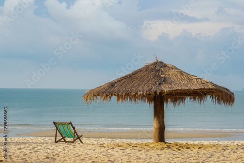 The morning sea has chairs and umbrellas on the beach as the foreground and the sea with the sky as the background.