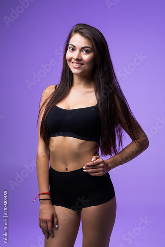 Sexy woman in black lingerie posing isolated on a violet background