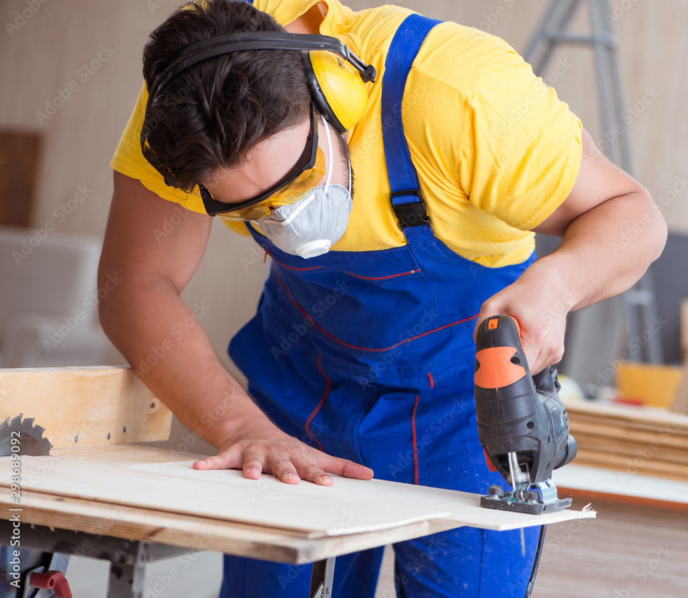 Young repairman carpenter working with a circular saw Young repairman carpenter working with a circular saw