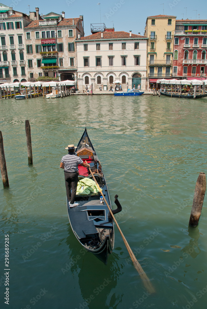 Venice, Italy: Gondolier enters his gondola in the Grand Canal nearby Rialto Bridge