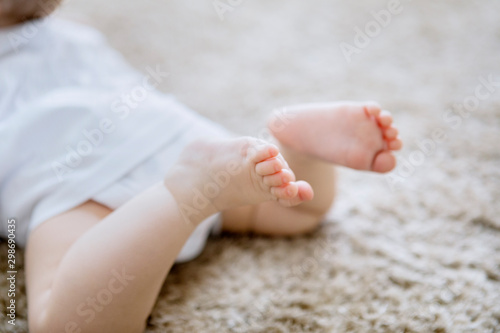 Close up of cute baby feet on the furry carpet