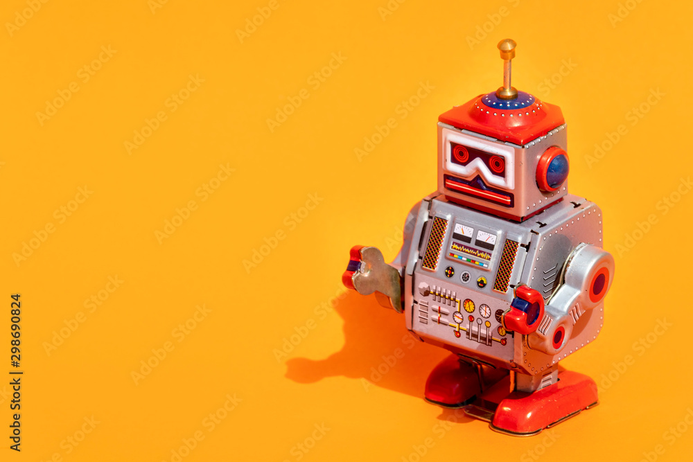 Obraz premium Antique tin toy robot on orange background. Vintage and classic concept free copy space for text.