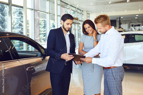 A couple buys a car in a car showroom.