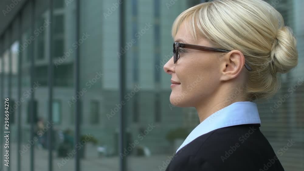 Female business person standing near office center and looking aside, confidence Female business person standing near office center and looking aside, confidence