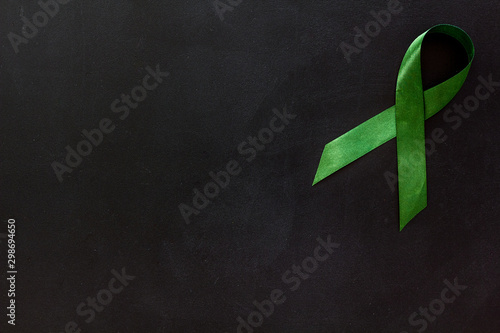 Green ribbon as symbol of disease control on white background top view space for text