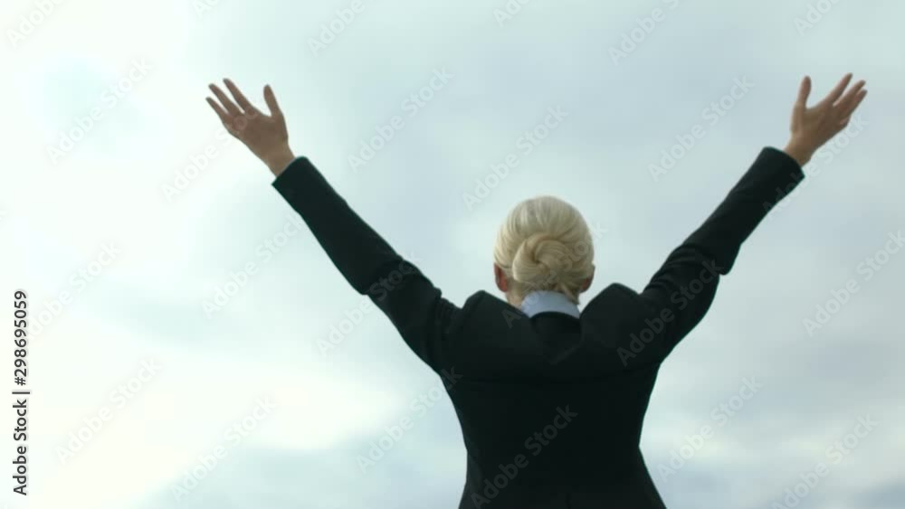 Female in business suit raising hands in victory gesture on sky background, free Female in business suit raising hands in victory gesture on sky background, free