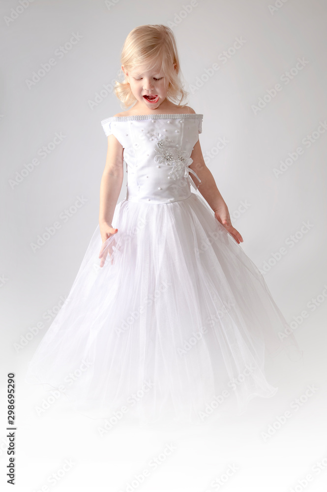 little girl in a wedding dress. pretty little girl in beautiful white dress isolated on light background. Copy space little girl in a wedding dress. pretty little girl in beautiful white dress isolated on light background. Copy space