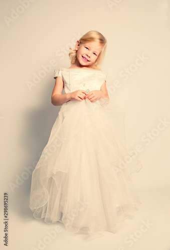 little girl in a wedding dress. pretty little girl in beautiful white dress isolated on light background