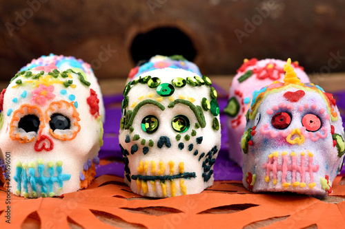 Skulls made by hand, made of sugar decorated with colored glass and sequins. Placed in confetti and wood. Days of the dead Mexican tradition