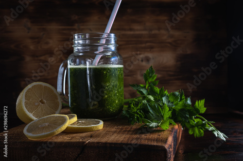 The smoothie poured into the Mason Jar next to it is cut pieces of lemon and celery leaves.