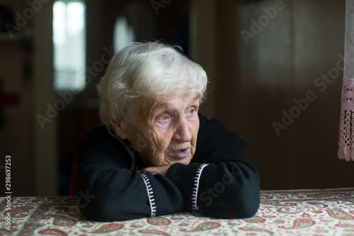 Portrait of elderly woman sitting in a room.