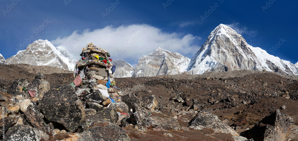 Pumori mount view and stone chorten with lungta prayer flags on the road to Everest Base Camp in Sagarmatha National Park, Nepal Himalaya