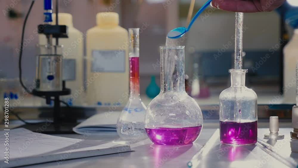 assistant pours powder into flask with liquid slow motion assistant pours powder into flask with liquid slow motion