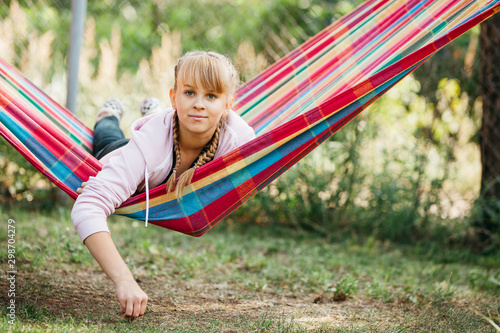 Teenage girl lying in colorful leisure hammock