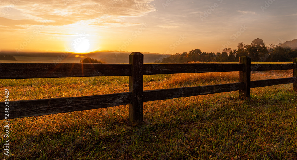 Fototapeta premium Split rail fence around North Carolina field at sunrise