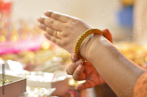 Wallpaper Mural Indian woman trying bridal golden traditional wedding bangles in a shop in North India, New Delhi, India Torontodigital.ca