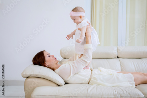 Young mother playing with her baby on couch