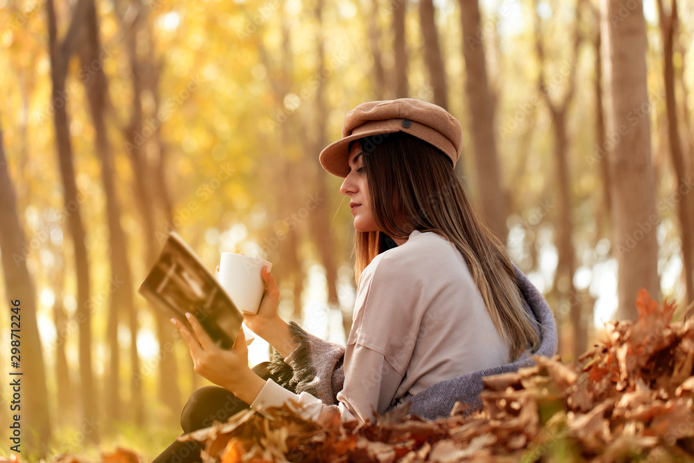 young woman reading a book in autumn park young woman reading a book in autumn park