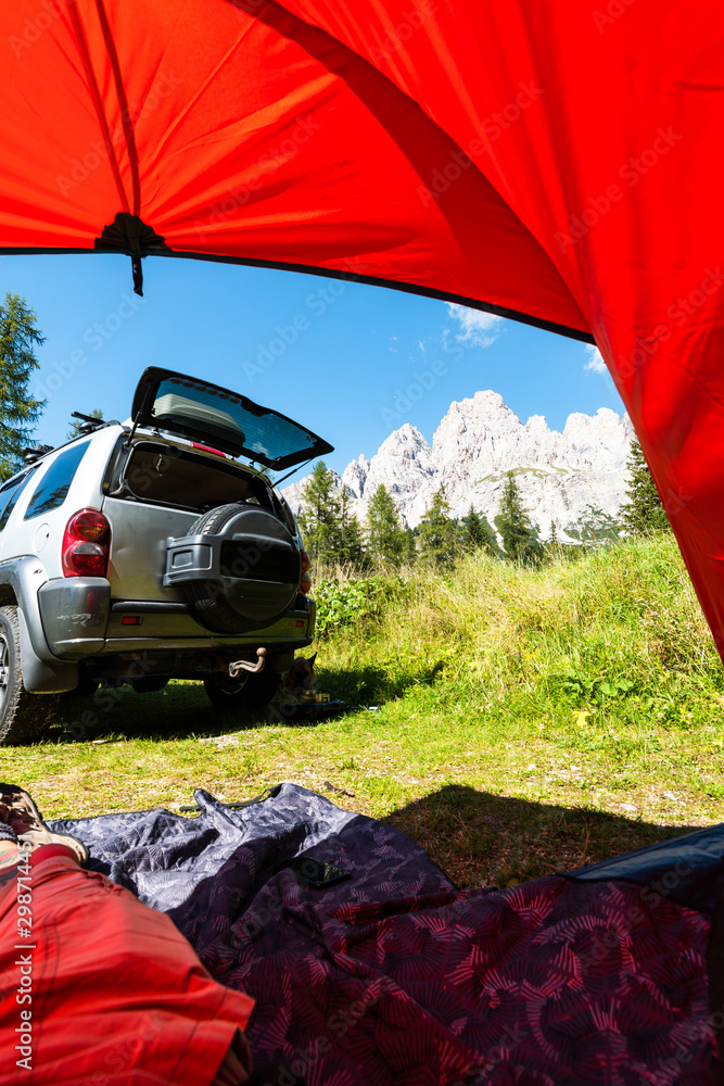 Tent and Off Road Car in Mountains. View From Tent. Outdoor Adventure